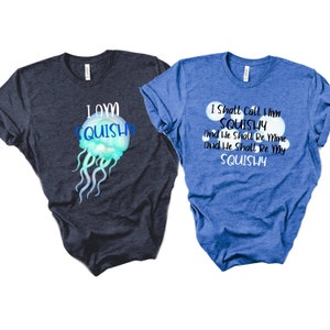 May include: Two t-shirts with a jellyfish theme. One shirt is dark blue with the text "I am squishy" and a blue jellyfish graphic. The other shirt is blue with the text "I shall call him squishy and he shall be mine and he shall be my squishy".