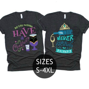 May include: Two dark grey t-shirts with a Frozen theme. The left shirt says "Do you wanna have a cocktail?" with a purple cocktail glass and ice cubes. The right shirt says "The wine never bothered me anyway" with a wine bottle pouring into a glass. The shirts are available in sizes S-4XL.