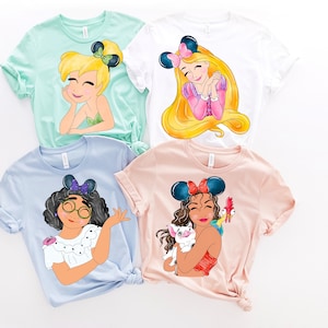 Pu&ograve; includere: Quattro magliette con diversi personaggi di principesse Disney stampati su di esse. Le magliette sono di vari colori, tra cui azzurro, rosa, bianco e verde. Ogni maglietta presenta una principessa diversa con un design e accessori unici.