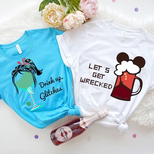 Könnte beinhalten: Zwei T-Shirts mit einem lustigen Party-Design. Ein Shirt ist hellblau mit einem grünen Weinglas mit einem Frauenkopf und Haaren und dem Text "Drink up, Glitches". Das andere Shirt ist weiß mit einem roten Bierkrug mit Mickey-Maus-Ohren und dem Text "Let's Get Wrecked".