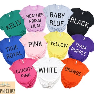 May include: Ten different colored t-shirts with various text printed on them. The colors are Kelly green, Heather Prism Lilac, Baby Blue, Black, True Royal, Pink, Yellow, Team Purple, Charity Pink, and White. The text on the shirts reads: Kelly, Heather Prism Lilac, Baby Blue, Black, True Royal, Pink, Yellow, Team Purple, Charity Pink, and White.