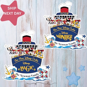 Puede incluir: Dos pegatinas con forma de barco de crucero de Disney. Una dice "Disney Wonder" y la otra "Disney Magic". Ambas tienen el texto "Our First Disney Cruise" y "The Newman Family". Las pegatinas presentan a Mickey Mouse, el Pato Donald y otros personajes de Disney.