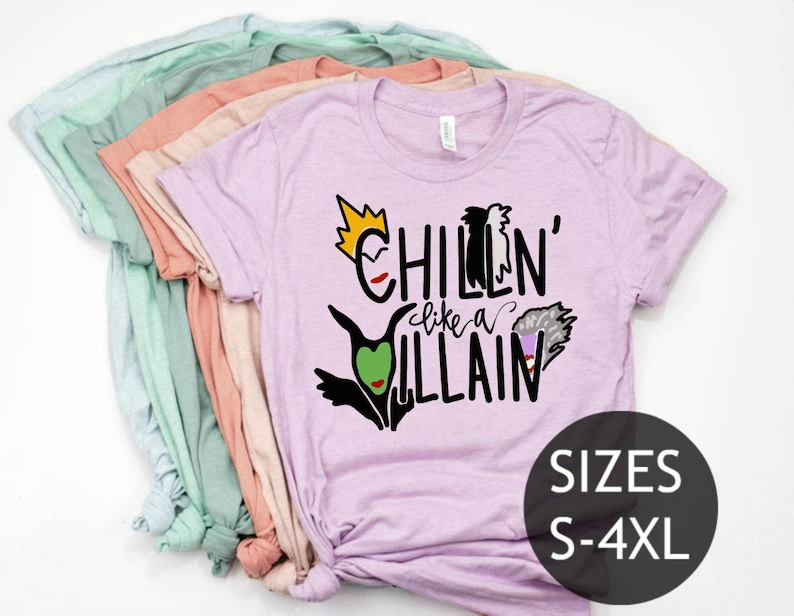 May include: A stack of t-shirts in various colors, with the top shirt being a light purple color. The shirt has a graphic print of Disney villains with the text "Chillin' like a Villain". The text "SIZES S-4XL" is printed on the bottom right corner of the shirt.