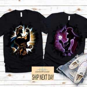 May include: Two black t-shirts with character graphics. One features a silhouette of a muscular figure with a blue cape, the other a silhouette of a woman holding a flower. The text "MIDNIGHT COMET" and "SHIP NEXT DAY" are also visible.