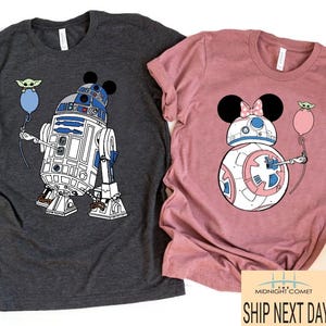 May include: Two t-shirts, one charcoal gray and one dusty rose, featuring Star Wars-themed designs. The gray shirt has a graphic of R2-D2 with Mickey Mouse ears and a Baby Yoda balloon. The pink shirt has a BB-8 design with Minnie Mouse ears and a Baby Yoda balloon.