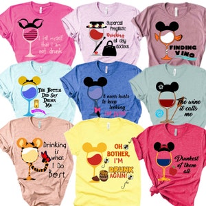 Puede incluir: Nueve camisetas diferentes con diseños de copas de vino y frases divertidas. Las camisetas son de varios colores, incluyendo rosa, amarillo, azul, verde y rojo. Las frases en las camisetas incluyen "Me digo a mí mismo que no estoy borracho", "Supercali Pragilistic Drinking all day docious", "Finding Vino", "The Bottle Did Say Drink Me", "Nunca hace daño seguir buscando vino", "El vino me llama", "Beber es lo que mejor hago", "Oh Bother, I'm Drunk Again!" y "El más borracho de todos".