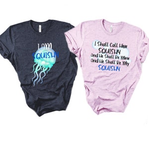 May include: Two t-shirts with a jellyfish graphic and text. The first shirt is dark blue with the text "I own squishy". The second shirt is pink with the text "I shall call him squishy and he shall be mine and he shall be my squishy".