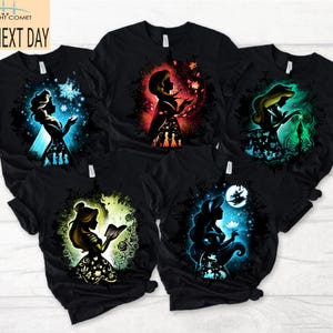 May include: Black t-shirts with colourful silhouette designs of animated characters. Each shirt displays a different character with unique background colours, including blue, red, and green. The shirts have a classic crew neck design.