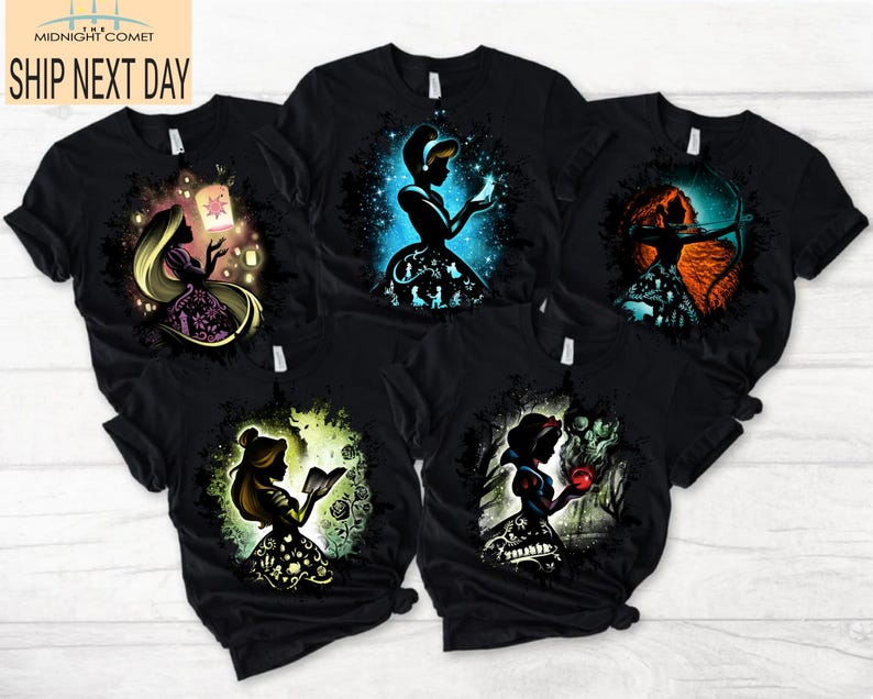 May include: Black t-shirts featuring colorful silhouette designs of fairytale characters. The designs include a princess with a lantern, a princess with a glowing ball, a princess with a bow and arrow, a princess reading a book, and a princess with an apple.