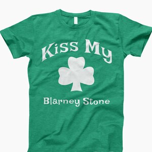 May include: Green t-shirt with white text that reads "Kiss My Blarney Stone" and a white shamrock.