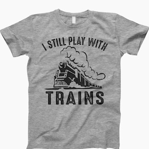 May include: A gray t-shirt with a black graphic of a train and the text "I still play with trains".
