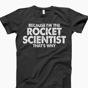 May include: Black t-shirt with white text that reads "Because I'm the Rocket Scientist That's Why".