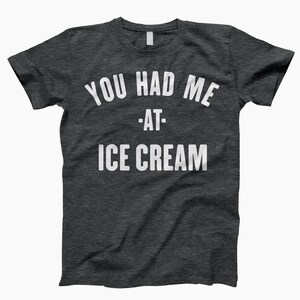 May include: Dark heather grey t-shirt with white text that reads "You had me at - ice cream".