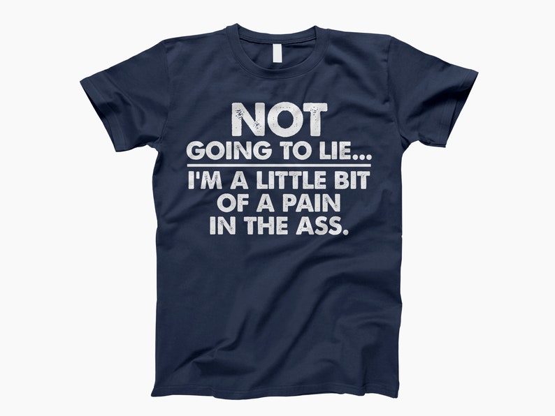 Op de afbeelding: Een marineblauw t-shirt met witte tekst die "NOT GOING TO LIE... I'M A LITTLE BIT OF A PAIN IN THE ASS." luidt.