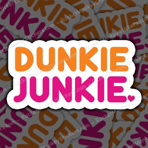 May include: A white sticker with the text "Dunkie Junkie." in orange and pink letters. A small pink heart is to the right of the text.