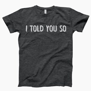 May include: A dark heather grey t-shirt with the text "I told you so" printed in white.