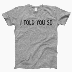 May include: A heather gray t-shirt with the text "I TOLD YOU SO" printed in black.