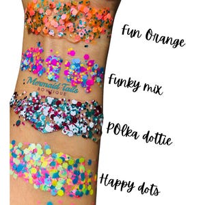 May include: Close-up of four glitter samples on skin. The top sample is orange and pink, followed by a mix of blue, pink, and purple. The third sample is white, teal, and burgundy, and the bottom sample is yellow, pink, and blue. Text reads "Fun Orange", "Funky mix", "Polka dottie", and "Happy dots".