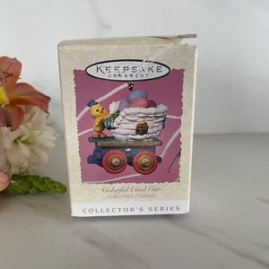 May include: A Keepsake Ornament Collector's Series box featuring a colorful, miniature train car with a basket of Easter eggs and a yellow chick. The train car is labeled "Colorful Coal Car Cottontail Express".