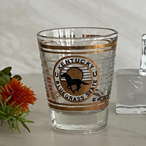 Vintage Kentucky Blue Grass State Souvenir Shot Glass with Gold Trim. Horse and Horseshoe. Signed MC Art Co. Made in Tiawan.