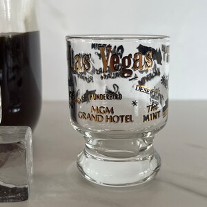 Las Vegas Nevada Vintage Pedestal Shot glass Souvenir. Black and Gold Graphics. Las Vegas Strip Hotels.