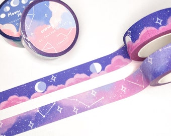 May include: Two rolls of washi tape with a purple and pink galaxy design. The tape features clouds, stars, and a crescent moon. The text on the tape reads "Evening Sky by Chelsea Street 15mm x 10m".