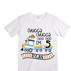 May include: White t-shirt with a blue and yellow train design. The train says "Chugga Chugga Choo Choo I'm 5 Rylan".