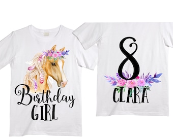 May include: Two white t-shirts with a horse design and floral accents. The front shirt has a brown horse with a floral crown and the text "Birthday Girl". The back shirt has the number "8" with floral accents and the name "Clara".