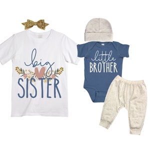 May include: A white t-shirt with the text "big sister" in blue with a pink heart and floral accents. A blue bodysuit with the text "little brother" in white. A pair of beige pants.