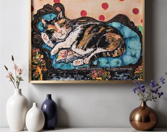 Puede incluir: Un cuadro enmarcado de un gato calicó descansando sobre una chaise longue azul capitoné, leyendo un libro. El fondo es de color melocotón claro con lunares rojos. El texto "Rachel Richardson | all rights reserved." aparece en la parte inferior.