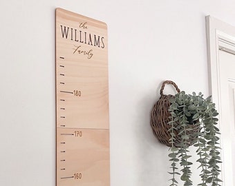May include: A wooden growth chart with the text "the WILLIAMS Family" at the top. The chart has markings for heights in inches, starting at 150 inches and going up to 180 inches.