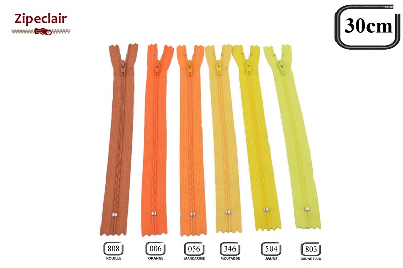 May include: Seven different colors of 30cm zipper tape, including rust, orange, mandarin, mustard, yellow, and two shades of yellow-green. The zipper tape is shown against a white background.