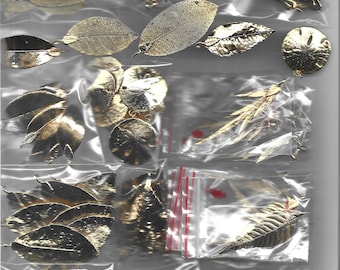 Pode incluir: Conjunto de enfeites de folha de ouro em vários formatos e tamanhos, embalados em sacos de plástico transparentes. As folhas são perfeitas para projetos de artesanato e scrapbooking.