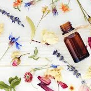 May include: A brown glass bottle with a cork stopper and a twine bow, surrounded by dried flowers in various colors, including lavender, yellow, orange, and pink.