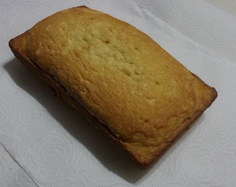 May include: A golden brown loaf of bread on a white paper towel.