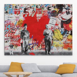 Può includere: Una stampa d'arte astratta colorata con due figure in bianco e nero, un cuore rosso e un personaggio di Topolino. Il testo "LOVE IS THE ANSWER" è visibile sulla stampa.
