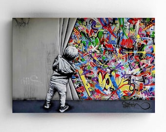 May include: A child peeks behind a white curtain revealing a colorful wall covered in graffiti. The graffiti is a mix of bright colors, including red, yellow, blue, green, and purple. The child is wearing a white shirt and black pants. The wall is covered in a variety of words and symbols.