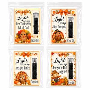 May include: Four clear plastic bags containing small black flashlights attached to Thanksgiving-themed cards. Each card features a turkey or scarecrow illustration, an orange bow, and text including Light em up and From: Colt.
