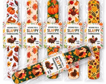 May include: Six rectangular slap bracelets in clear plastic packaging, each featuring colorful Thanksgiving-themed patterns like pumpkins, turkeys, and autumn leaves. Each bracelet has a paper tag reading WISHING YOU A SLAPPY THANKSGIVING from Jada.