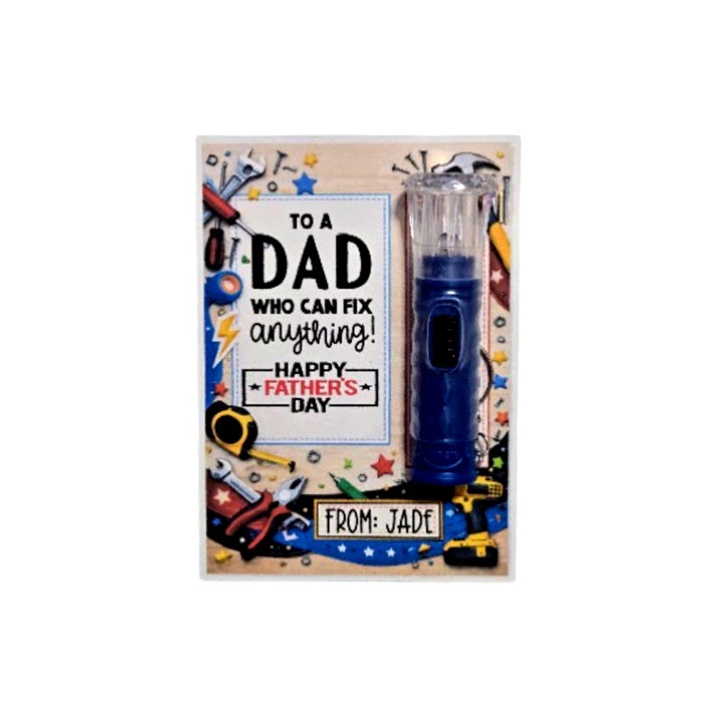 Pu&ograve; includere: Un regalo per la festa del pap&agrave; con un cacciavite elettrico blu e un messaggio che dice: "A un pap&agrave; che pu&ograve; aggiustare qualsiasi cosa! Buona festa del pap&agrave;". Il regalo &egrave; decorato con attrezzi e le parole "Da: Jade".