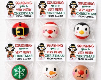 Pode incluir: Seis sacos de plástico transparente com brinquedos redondos e macios com temas natalícios. Cada saco tem um cartão branco com um desenho de rena e o texto SQUISHING you a VERY MERRY CHRISTMAS! FROM: GIANNA. Os brinquedos apresentam designs de Pai Natal, pinguim, boneco de neve e floco de neve.