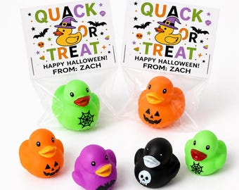 May include: Two clear plastic bags containing rubber ducks with header cards reading QUACK OR TREAT HAPPY HALLOWEEN FROM ZACH. Four loose rubber ducks in orange, purple, black, and green are arranged in front, featuring spiderweb, jack-o-lantern, bat, and skull designs.