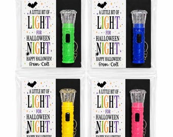 May include: Four small plastic flashlights with keychains, each in a different color: green, blue, yellow, and pink. Each is packaged in a clear bag with a card reading A LITTLE BIT OF LIGHT FOR HALLOWEEN NIGHT HAPPY HALLOWEEN! From Colt.