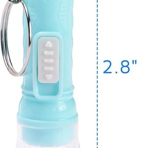 May include: A light blue flashlight with a clear, textured bottom. The flashlight is 2.8 inches tall and 0.5 inches wide. It has a silver keyring attached and a white button panel. The flashlight is cylindrical in shape.