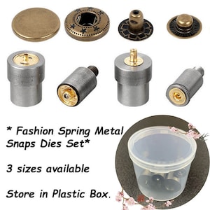 May include: A collection of metal snap dies in various shapes and sizes, including round and star-patterned designs. The set includes several silver-colored tools and is stored in a clear plastic container. The text on the image reads "Fashion Spring Metal Snaps Dies Set."