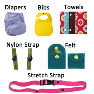 May include: A set of baby accessories including a purple diaper, yellow bib, multi-colored towels, green nylon straps, teal and blue felt pouches, and a pink stretch strap. All items feature snap buttons.