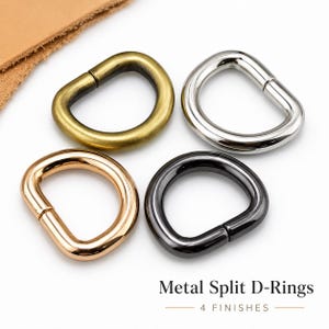 Op de afbeelding: Vier metalen gespleten D-ringen in vier verschillende afwerkingen: antiek messing, gepolijst zilver, roségoud en gunmetal zwart. Elke D-ring heeft een gladde, ronde vorm met een zichtbare naad. De tekst Metal Split D-Rings 4 FINISHES is zichtbaar.