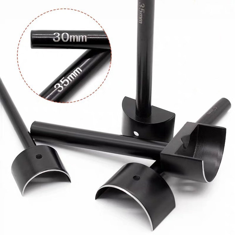 May include: Black leathercraft tools with semi-circular cutting heads. The tools have long handles and are labeled with measurements of 30mm and 35mm. The tools are designed for cutting leather.