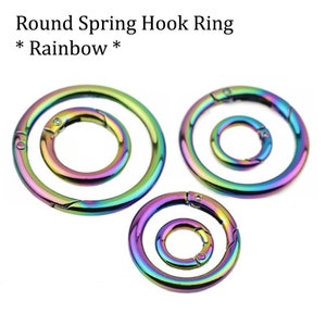 May include: Three round spring hook rings in various sizes. The rings are rainbow colored with a metallic finish.