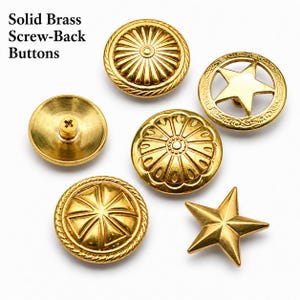 May include: A selection of solid brass screw-back buttons. The image shows gold-coloured buttons with different designs, including floral patterns and a star shape. The text reads "Solid Brass Screw-Back Buttons".